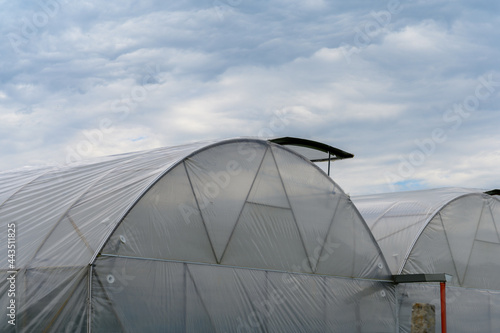 Greenhouses in Ukraine against the sky with clouds.