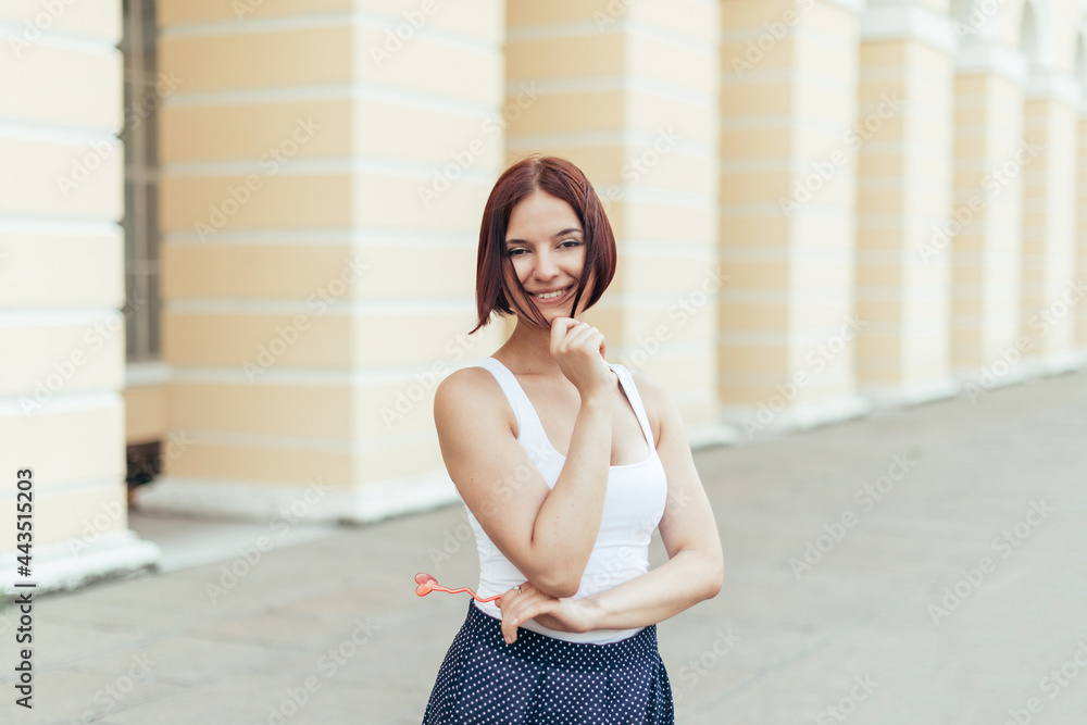 Happy caucasian red-haired girl holding an accessory heart and smiling with sympathy Happy caucasian red-haired girl holding an accessory heart and smiling with sympathy