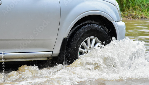 Wheels of the pickup car which passing the floodwater.