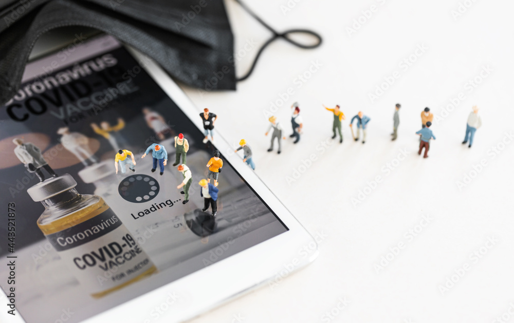 Group of people (figurine) standing on digital tablet during COVID-19 vaccine aplication downloading. Coronavirus vaccine, population immunization campaign concept. Group of people (figurine) standing on digital tablet during COVID-19 vaccine aplication downloading. Coronavirus vaccine, population immunization campaign concept.