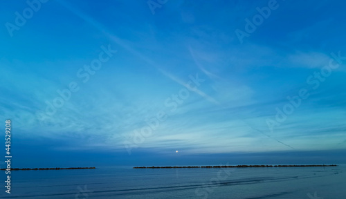 Tramonto sul mare con luna nel cielo