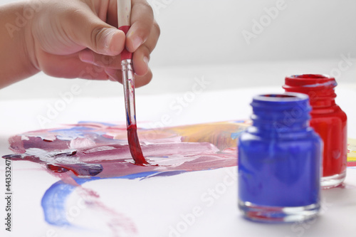 Asian boy use paintbrush and watercolor painting