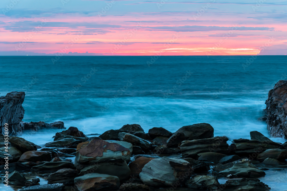 Rocky Sunrise at the seaside with cloud cover and headland Rocky Sunrise at the seaside with cloud cover and headland