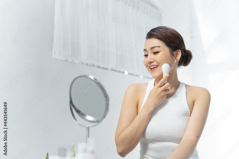 beautiful asian woman and hand holdind electric facial massage isolated on white background beautiful asian woman and hand holdind electric facial massage isolated on white background