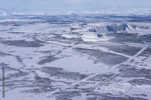 Aerial shot of the Kiruna area with a road in Lapland in Sweden in winter. At the top right the factories of the LKAB, a large Swedish mining company photo