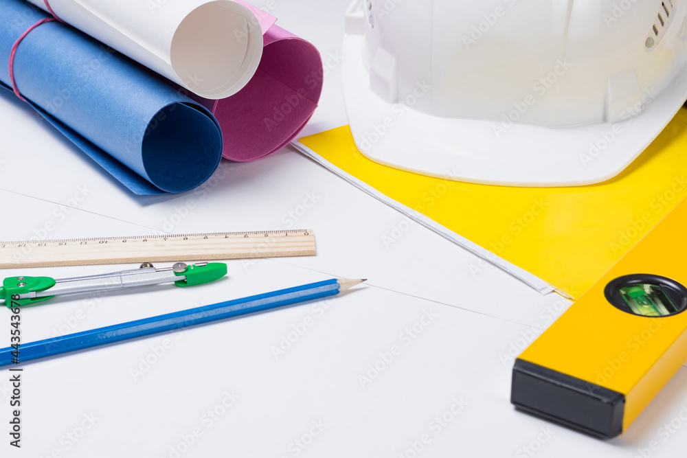 Construction concept and building design. Work table of an engineer, builder. Construction helmet, stationery. Selective focus. Construction concept and building design. Work table of an engineer, builder. Construction helmet, stationery. Selective focus.