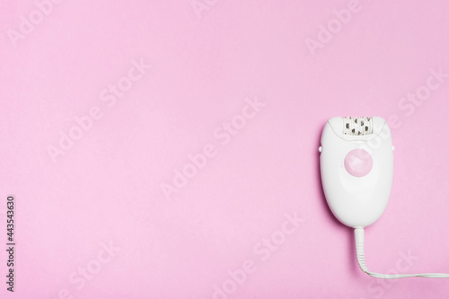 Body beauty concept. Epilator hair removal device on a pink background.