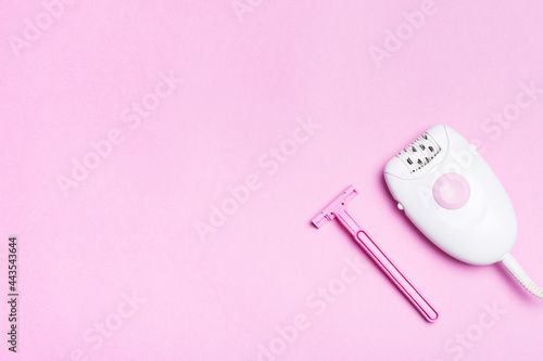 Body beauty concept. Epilator hair removal device and safety razor on a pink background.
