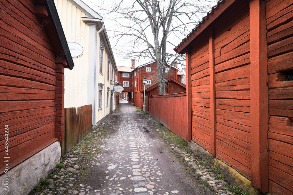 LINKÖPING, SWEDEN, MARCH 14, 2020: View of traditional timber houses with deep Falu red or falun red paint in the old town Gamla Linkoping, Sweden