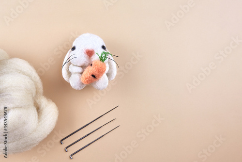 Felted handmade bunny near the skein of wool and needles.