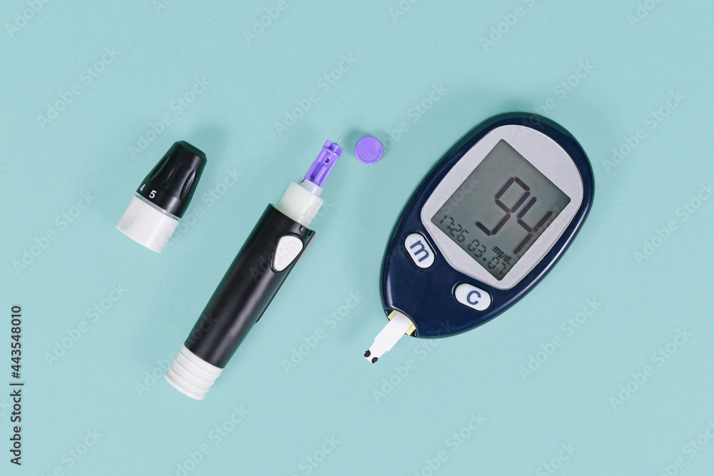 Tools for diabetes treatment with blood glucose sugar meter showing blood  sugar of 94 and lancing device with lancet on blue background Stock-Foto |  Adobe Stock