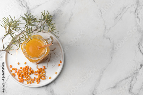 Mason jar of healthy sea buckthorn tea on white background