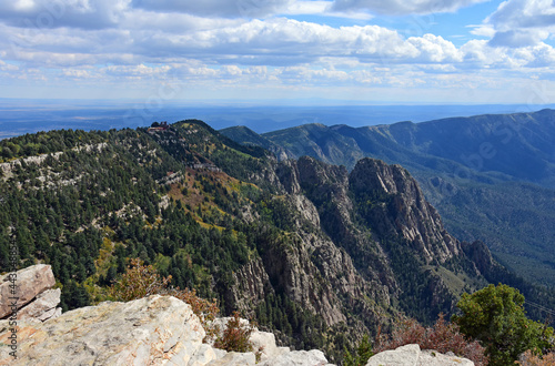 looking out at the sandia peak tramway terminus, forest,and granite peaks on a fall day from sandia peak, new mexico