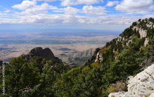 panoramic view of albuquerque, forest, and granite peaks on a fall day from sandia peak, new mexico