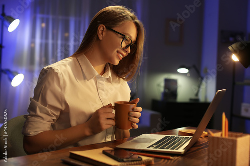 Female freelancer working at home late in evening