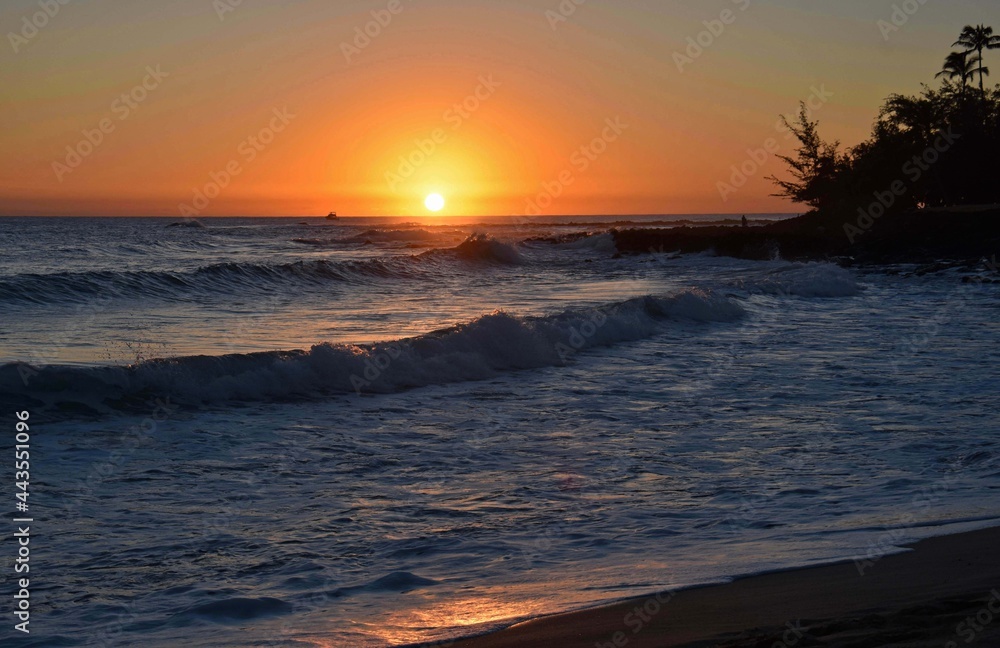 Obraz premium sunset and crashing waves in poipu, kauai, hawaii, as seen from brennecke's beach