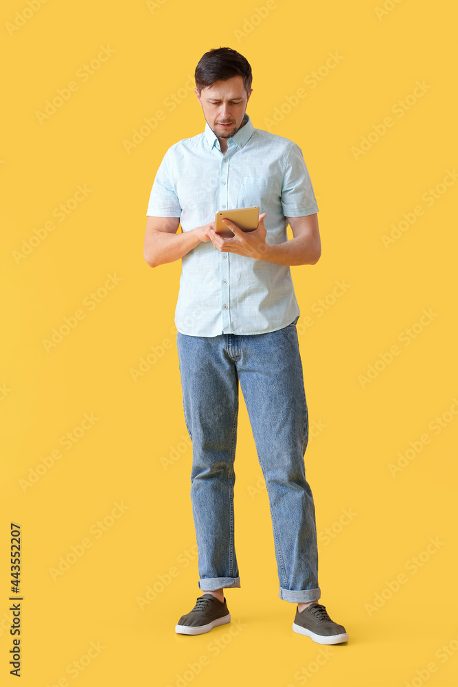 Handsome man using tablet computer on color background Handsome man using tablet computer on color background