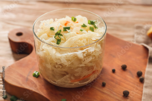 Bowl with tasty sauerkraut on wooden table