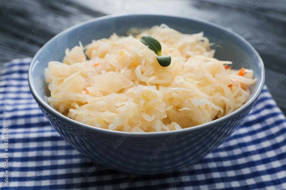 Bowl with tasty sauerkraut on dark wooden background Bowl with tasty sauerkraut on dark wooden background