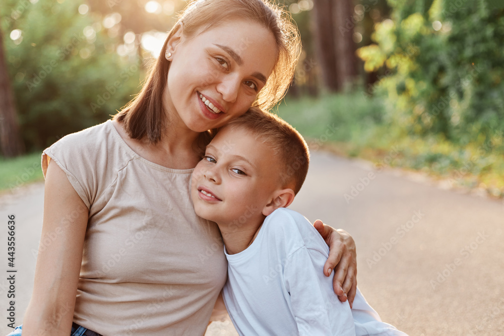 Portrait of mother and son smiling and hugging each other and looking at camera, happy family outdoor, having fun together in summer park, childhood, motherhood. Portrait of mother and son smiling and hugging each other and looking at camera, happy family outdoor, having fun together in summer park, childhood, motherhood.
