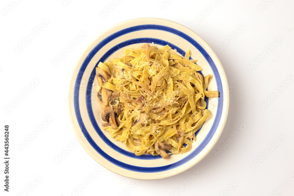 Pasta Penne with chicken and mushroom under parmesan cheese served on a plate over white background