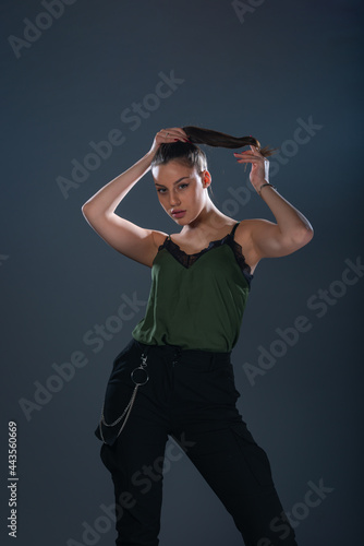 Fashion sexy picture of an attractive woman posing while  holding her ponytail