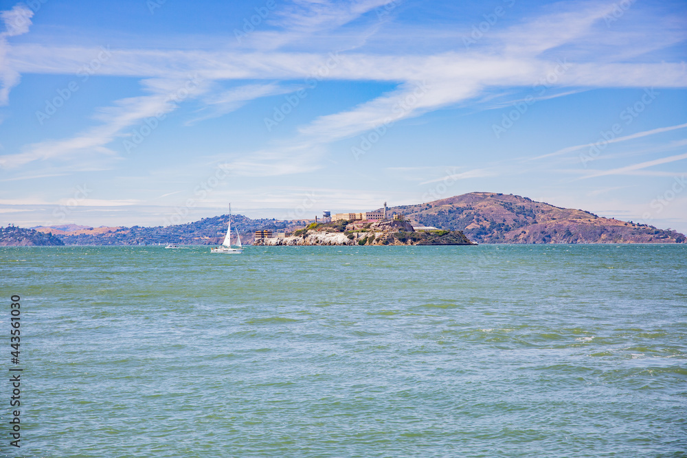 Sail boat sailing by Alcatraz Prison in San Francisco Bay Sail boat sailing by Alcatraz Prison in San Francisco Bay