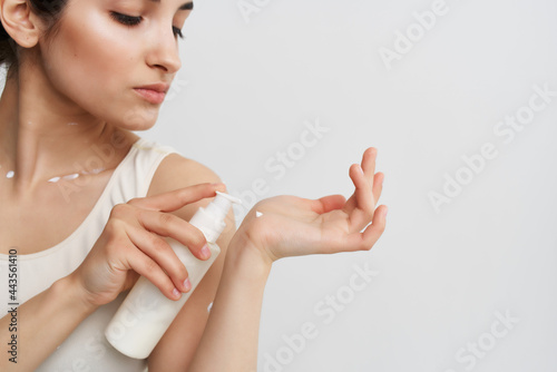 pretty woman in white t-shirt cosmetics skin care light background