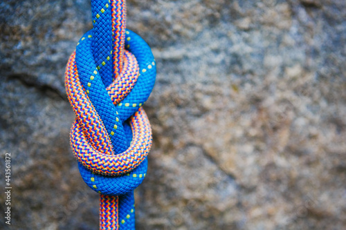 eight rope knot on rocky background photo