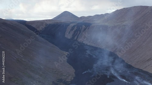 Volcanic gases rises from black basalt lava field in Iceland valley photo