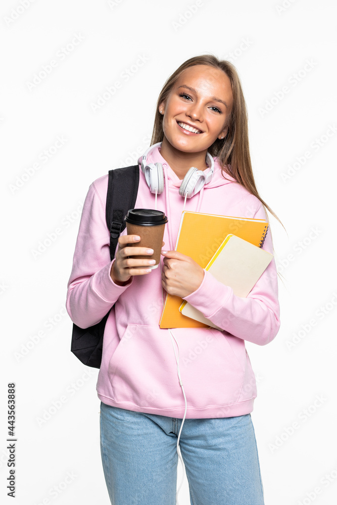 Portrait of a happy woman student with backpack writing in a notepad while standing with books isolated over white background Portrait of a happy woman student with backpack writing in a notepad while standing with books isolated over white background