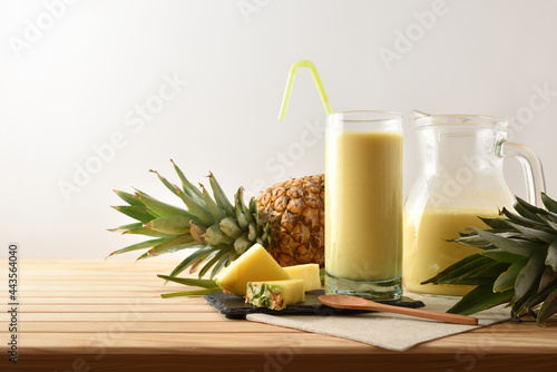 Foto Glass and jug with pineapple juice isolated background.
