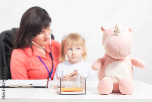 aucasian doctor pediatric therapist listens with a stethoscope to the lungs of a child who has a cough. Concept for the treatment of bronchitis and pneumonia in children photo