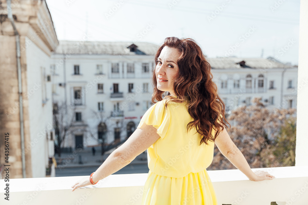 Portrait of a beautiful brunette woman in a yellow summer dress
