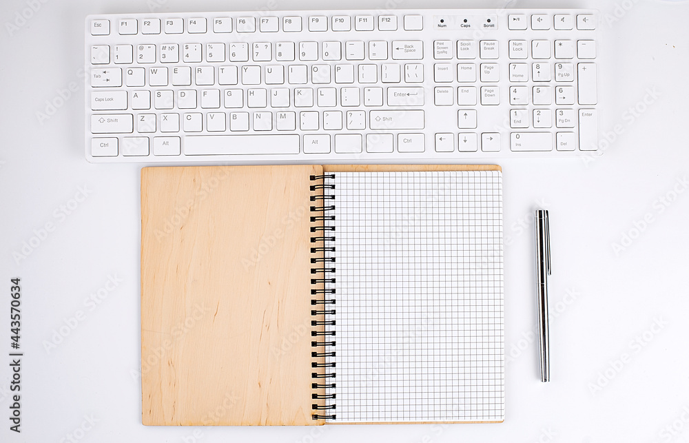 Top view of white desk with keyboard and notebook. Copy space Top view of white desk with keyboard and notebook. Copy space