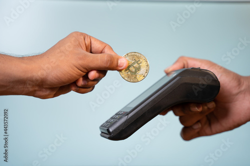 Concept showing of cryptocurrency payment - Hands paying buy placing on swiping payment machine. photo