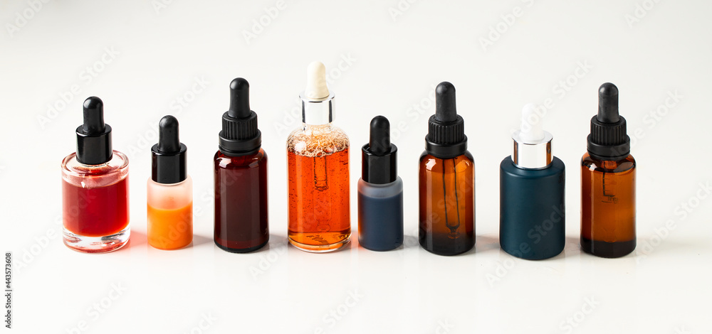 Different crystal bottles with bio serum, natural oil and cream on large background for web banner. Modern cosmetic and skin care concept. banner Different crystal bottles with bio serum, natural oil and cream on large background for web banner. Modern cosmetic and skin care concept. banner