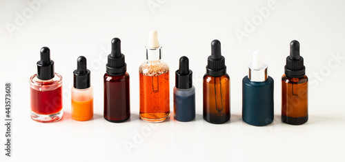 Different crystal bottles with bio serum, natural oil and cream on large background for web banner. Modern cosmetic and skin care concept. banner