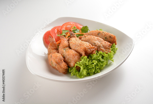 deep fried golden crispy prawn meat ball roll traditional wu Xiang with spicy sauce in white background asian halal snack menu