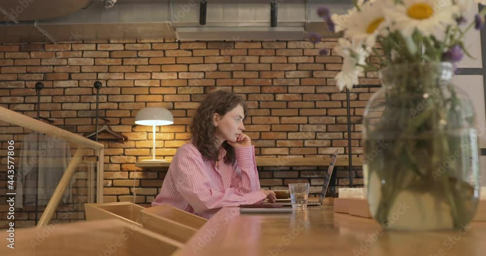 Young woman using laptop computer surfing social media, checking news, playing mobile games or texting messages. Millennial girl spending time at restaurant, coffee shop. Young woman using laptop computer surfing social media, checking news, playing mobile games or texting messages. Millennial girl spending time at restaurant, coffee shop.