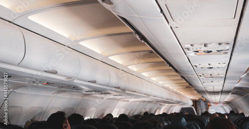 Interior of a plane with passengers on their seats .