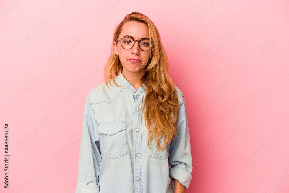 Caucasian blonde woman isolated on pink background sad, serious face, feeling miserable and displeased.