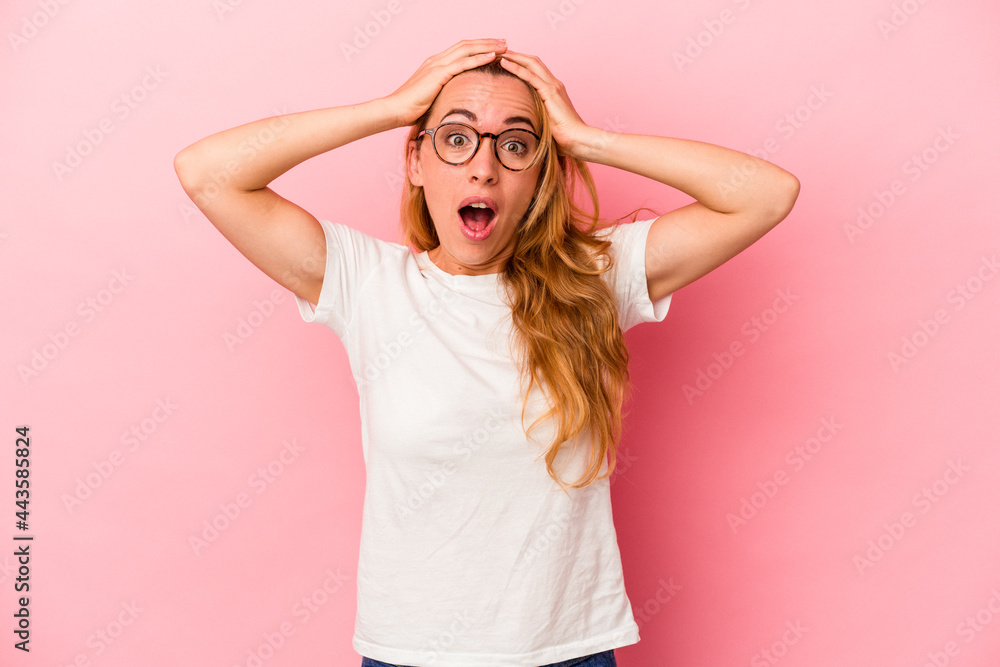 Caucasian blonde woman isolated on pink background surprised and shocked. Caucasian blonde woman isolated on pink background surprised and shocked.