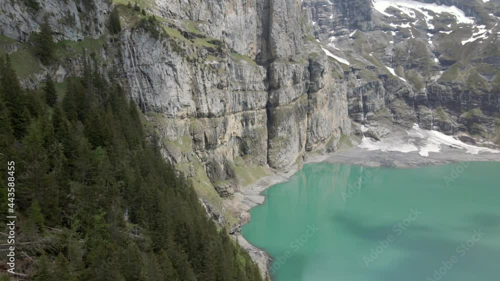 Vertical mountain cliffs reflecting in the light blue water of the Oeschinesee in Switzerland Vertical mountain cliffs reflecting in the light blue water of the Oeschinesee in Switzerland