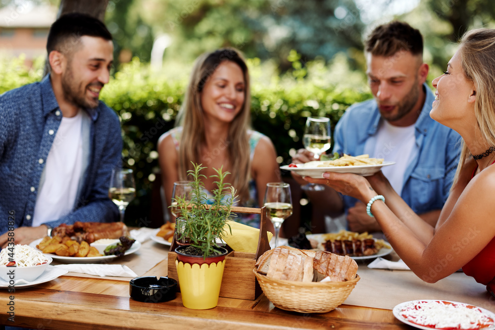 Group of Happy friends having lunch in the restaurant during a sunny summer day Group of Happy friends having lunch in the restaurant during a sunny summer day
