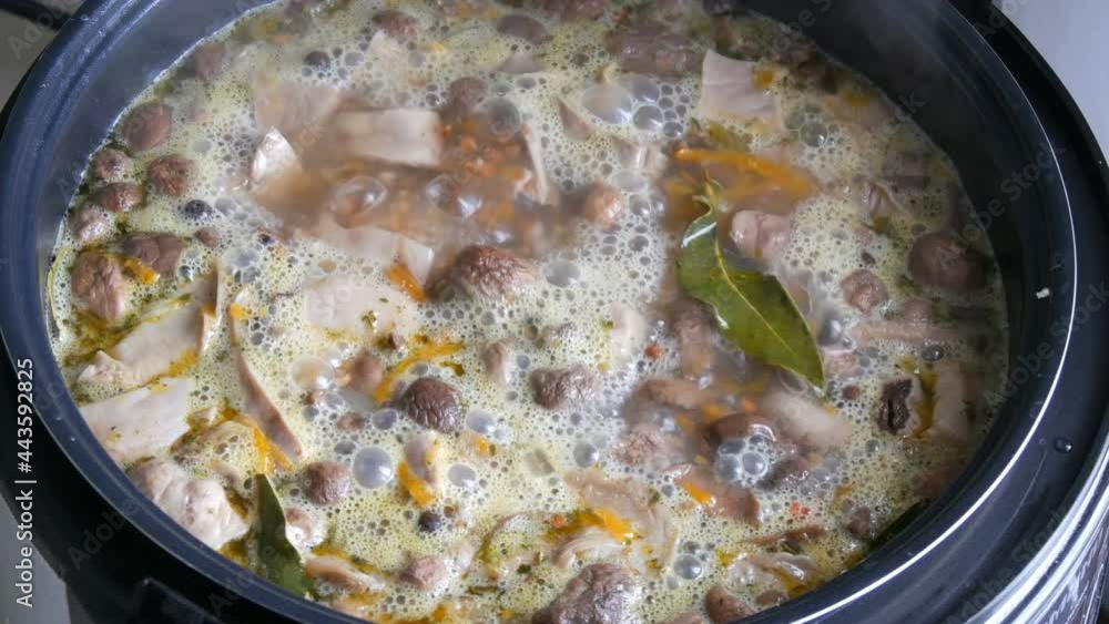 Boiling in pan mushroom soup with carrots bay leaf potatoes and spices close up view Boiling in pan mushroom soup with carrots bay leaf potatoes and spices close up view