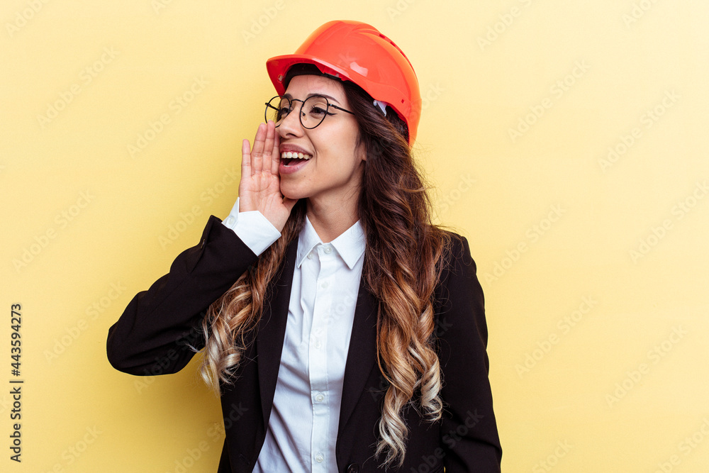 Young architect mixed race woman isolated on yellow background shouting and holding palm near opened mouth. Young architect mixed race woman isolated on yellow background shouting and holding palm near opened mouth.