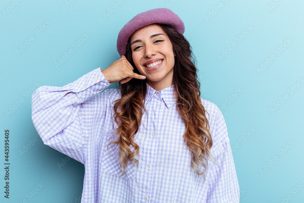 Young mexican woman isolated on blue background showing a mobile phone call gesture with fingers. Young mexican woman isolated on blue background showing a mobile phone call gesture with fingers.
