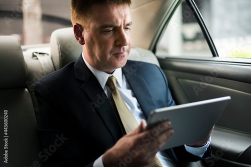 Businessman using a tablet in a car © Rawpixel.com