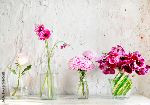 A row of vases with pink flowers